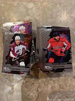 Two stacks of hockey cards, front side showing players Cale Makar (Colorado Avalanche) and Alex Ovechkin (Washington Capitals) from the 2020-21 Metal Universe set with metallic finish.