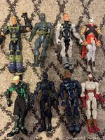 Photo showing the full set of 8 action figures arranged on carpet, visible variety in designs and colors.