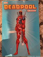 Front cover showing Deadpool standing with swords and smoke, blue background, Marvel branding