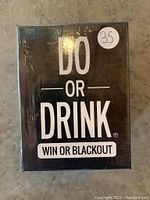 Front of sealed game box showing title 'Do Or Drink - Win Or Blackout' with price sticker.