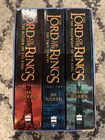 Spine view showing three Lord of the Rings hardcover books by JRR Tolkien in slipcase, titles and part numbers clear