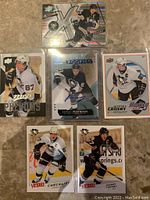 Top view of 6 hockey cards including Sidney Crosby and Sergei Plotnikov autograph card in protective case.