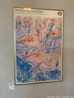 Full view of framed poster depicting several flamingoes in a colorful artistic style, with the title 'The Flamingoes by Tube' and branding related to the London Tube.