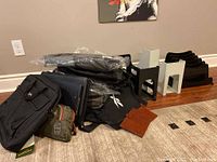Overall view of the bags, file sorters, and accessories arranged on floor near wall with visible power outlet and carpet.