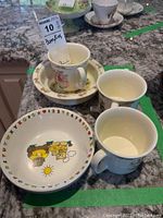 Photo showing the Royal Doulton Bunnykins ceramic bowl, three Bunnykins mugs, and two plastic bowls on a countertop.