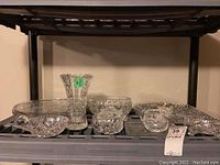 Photo showing 8 pieces of crystal and glassware with pinwheel designs including a vase, platters, candy dishes, cream and sugar set, and bowls.