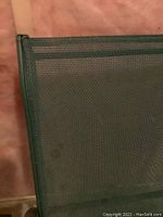 Close-up showing green mesh fabric on a lawn chair seat.