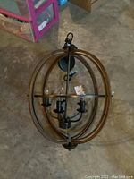 Overall view of the metal hanging light fixture showing the oval frame and bulb sockets.