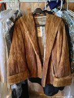 Front view of brown mink fur jacket showing natural fur texture and cuffed sleeves