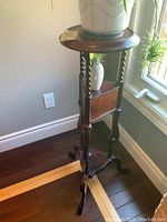 Front view of plant stand showing round top, barley twist legs and two drawers