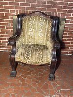 Front view of the mahogany claw foot chair displaying patterned upholstery and curved armrests.