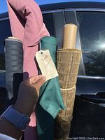 Close-up of fabric rolls showing texture and the yards tag on the teal green fabric.