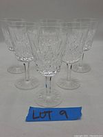 Front view of all six Waterford crystal wine glasses showing detailed cut patterns and clear stems.