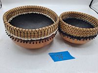 Two natural gourd baskets with woven straw rims and bead accents, showing lot from top and front angles.