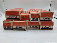 Boxes stacked on ends showing item number and type information: 2 boxes labeled No. 6462 Gondola Car, No. 6019 Remote Control Track Set plus other Lionel car boxes.