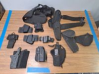 Full layout view of all holsters and belts on wooden table