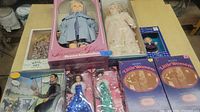 Lot of 10 vintage dolls in original boxes and plastic packaging, showing diverse styles and packaging conditions.