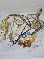 Full lot overview showing an assortment of chains, beads, bracelets, and pins with mixed materials and styles.