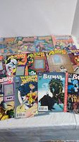 Overview of lot showing Outsiders titles at top, Robin holographic issues, Wonder Woman and Batman issues front