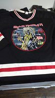 Black Iron Maiden hockey jersey with red and white stripes and Eddie graphic