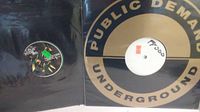 Vinyl record labeled 'Public Demand Underground' partially removed from sleeve showing label and record condition.