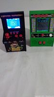 Two handheld arcade games, Frogger and 200-in-1 retro game, shown from front and side.