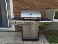 Front view of Char-Broil Classic gas BBQ grill with closed lid, showing stainless steel finish, control knobs, side shelves, and storage cabinet.