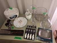 Photo showing full assortment of tableware including plates, vases, cups, bowl, utensils arranged on table