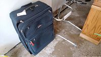 Photo of black Air Canada branded suitcase with visible multiple compartments and a tag attached to the handle.