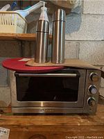 Cuisinart convection toaster oven broiler with two stainless steel thermoses and placemats on top