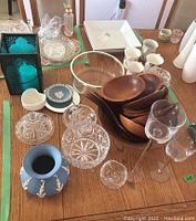 Photo of wooden bowls, Wedgwood blue vase, glass bowls, glassware, white serving plates, and mugs