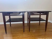 Pair of matching wood end tables photographed together, showing front and side angles and overall design, color, and condition.