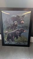 Framed 3D bear print showing two bears near water and a large bear head in the background, framed in black.