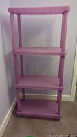 Front view of the four-tier purple plastic storage shelf with vertical poles and flat shelves.