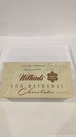 Top view of vintage Willard's Ann Hathaway chocolate box with handwritten label indicating it holds embroidery cotton.