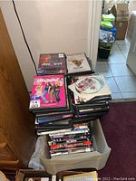 Stack of DVDs with some discs loose, various titles visible