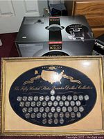 Photo of boxed Keurig 2.0 K300 brewer alongside framed 50 states quarter collection display.