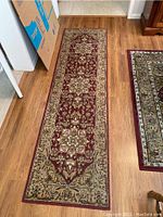 Photo of the long runner laid out on wood flooring showing full length and border pattern