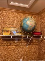 Photo of vintage globe, recipe box with cards, and the red mixing bowl on a shelf