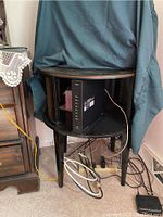 Round side table with dark finish, metal mesh side panels, and stencil decorative details on the top surface. The table is approximately 24 x 28 inches. The table appears sturdy and lightly used.