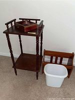 Full view showing wooden telephone table with drawer (needs repair), magazine rack on floor, and white waste basket.