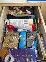 Drawer with rubber bands, pens, instructions, and small tool items.