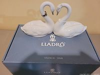 Figurine of two swans placed on original blue Lladró box showing logo and location 'Valencia - Spain'