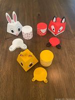 Wooden stacking toys disassembled showing various magnetic pieces forming bunny, fox, and cat figures.