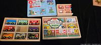 Photo of all wooden vehicles, traffic signs, and train cars neatly organized in wooden trays with packaging.