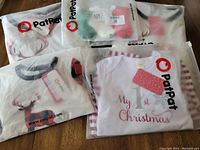 Photo showing multiple packaged pajama tops and socks inside transparent PatPat bags on wooden floor