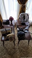 Full view of both matching wooden side tables and the collection of vintage electronics including radios, rotary phone, box fan, lamps, and alarm clock arranged on tables.
