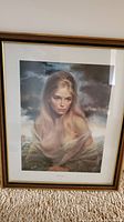 Full view of the framed print showing the portrait of a blond woman with a moody sky background.