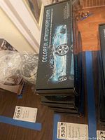 Top view of stacked boxes labeled 'Colorful Atmosphere Lights' with image of a blue convertible car. Showing the lot contents of five individual boxed lights.