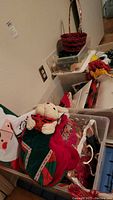 Bins showing multiple Christmas decorations including stockings, stuffed plush items, and baskets.